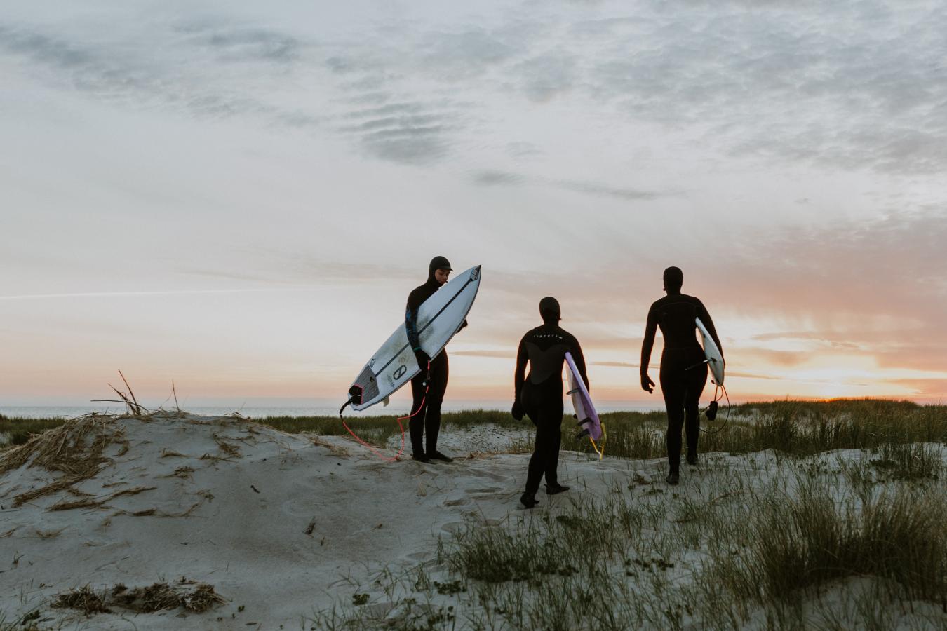 Surfers on a dune in sunset by the North Sea