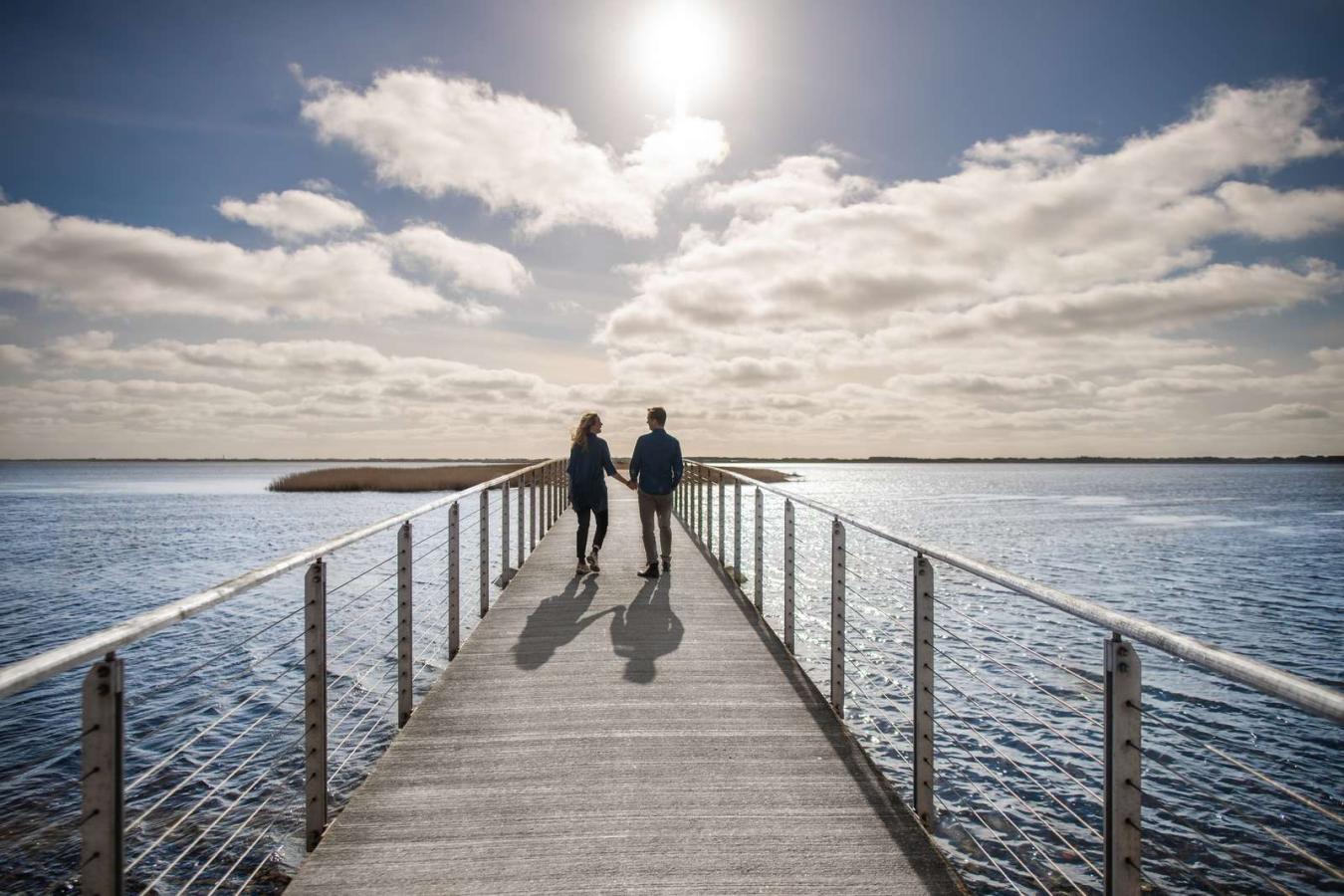Couple walking on bridge at visitvesterhavet the North Sea 