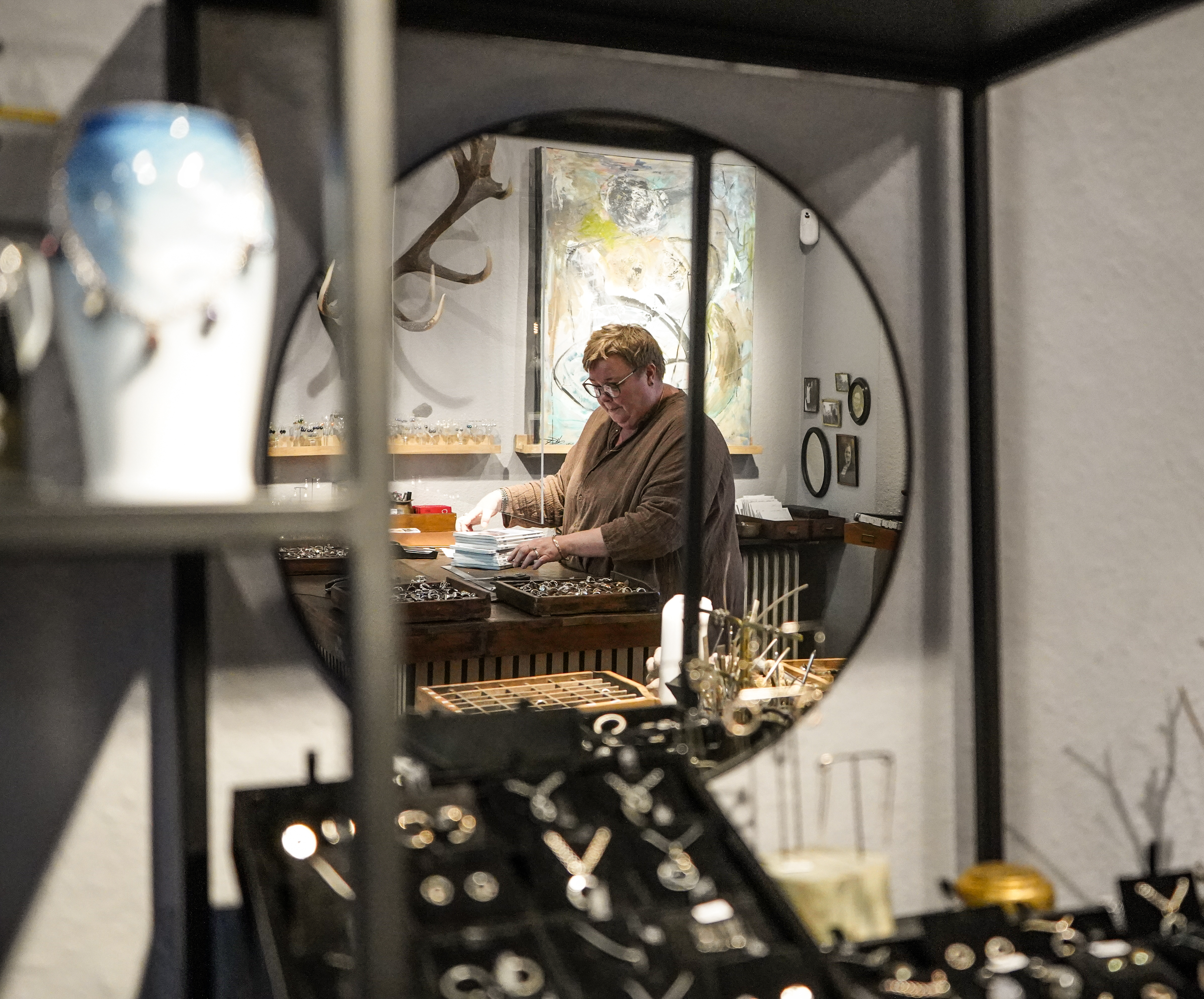 Kvinde står bag disk i smykkeforretning