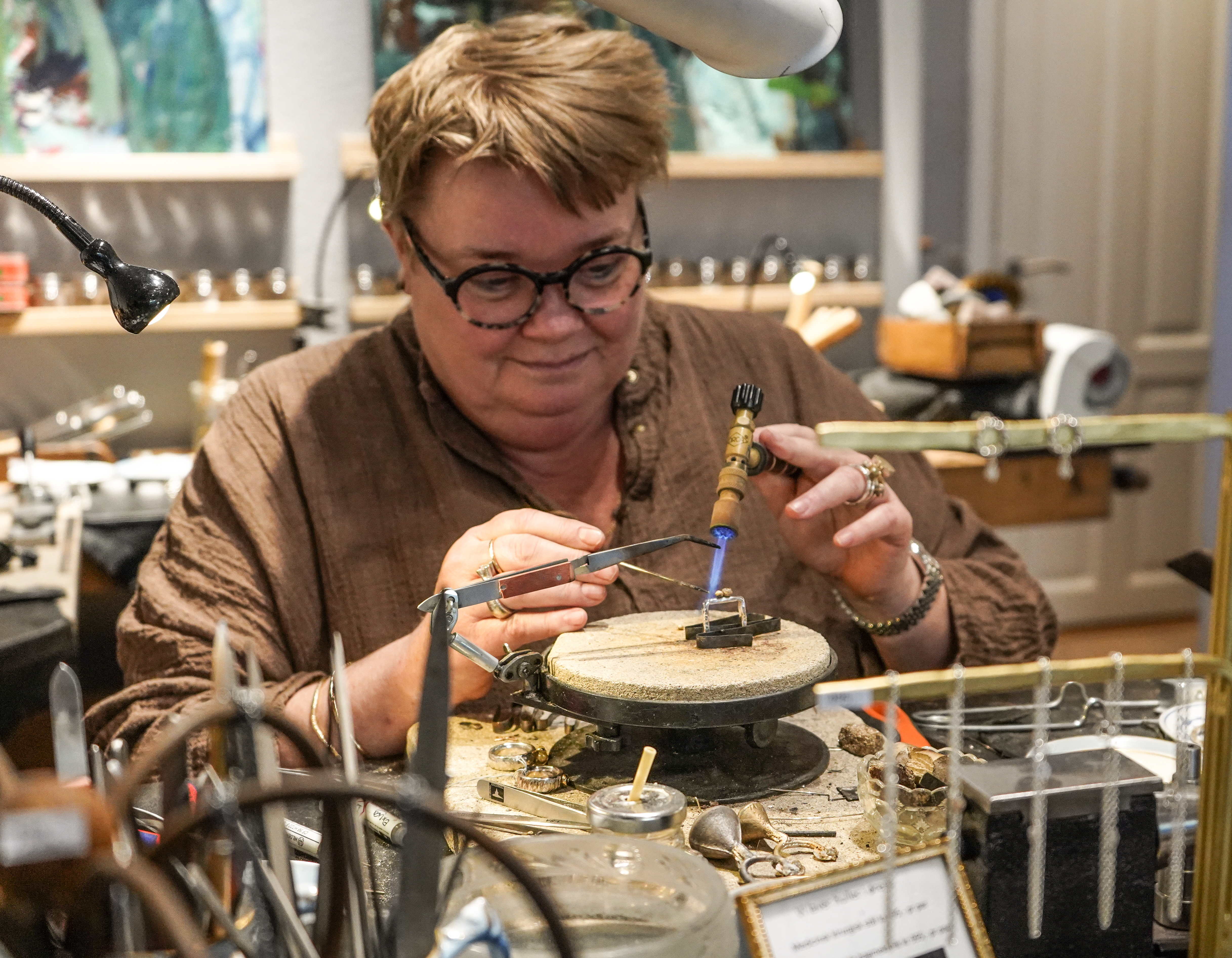 Kvinde står bag disk i smykkeforretning