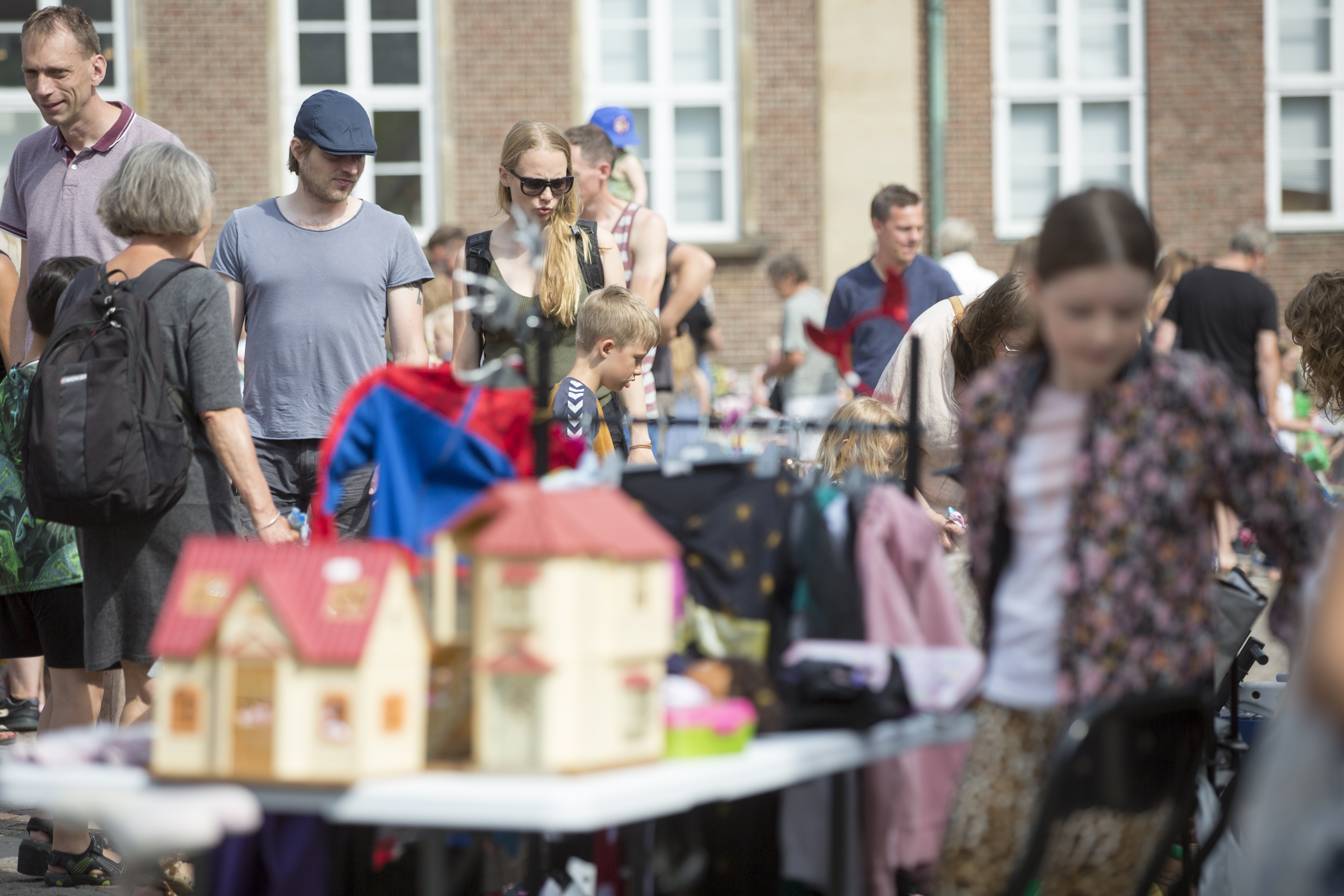 Mennesker går rundt og kigger på loppemarked på torvet i Varde