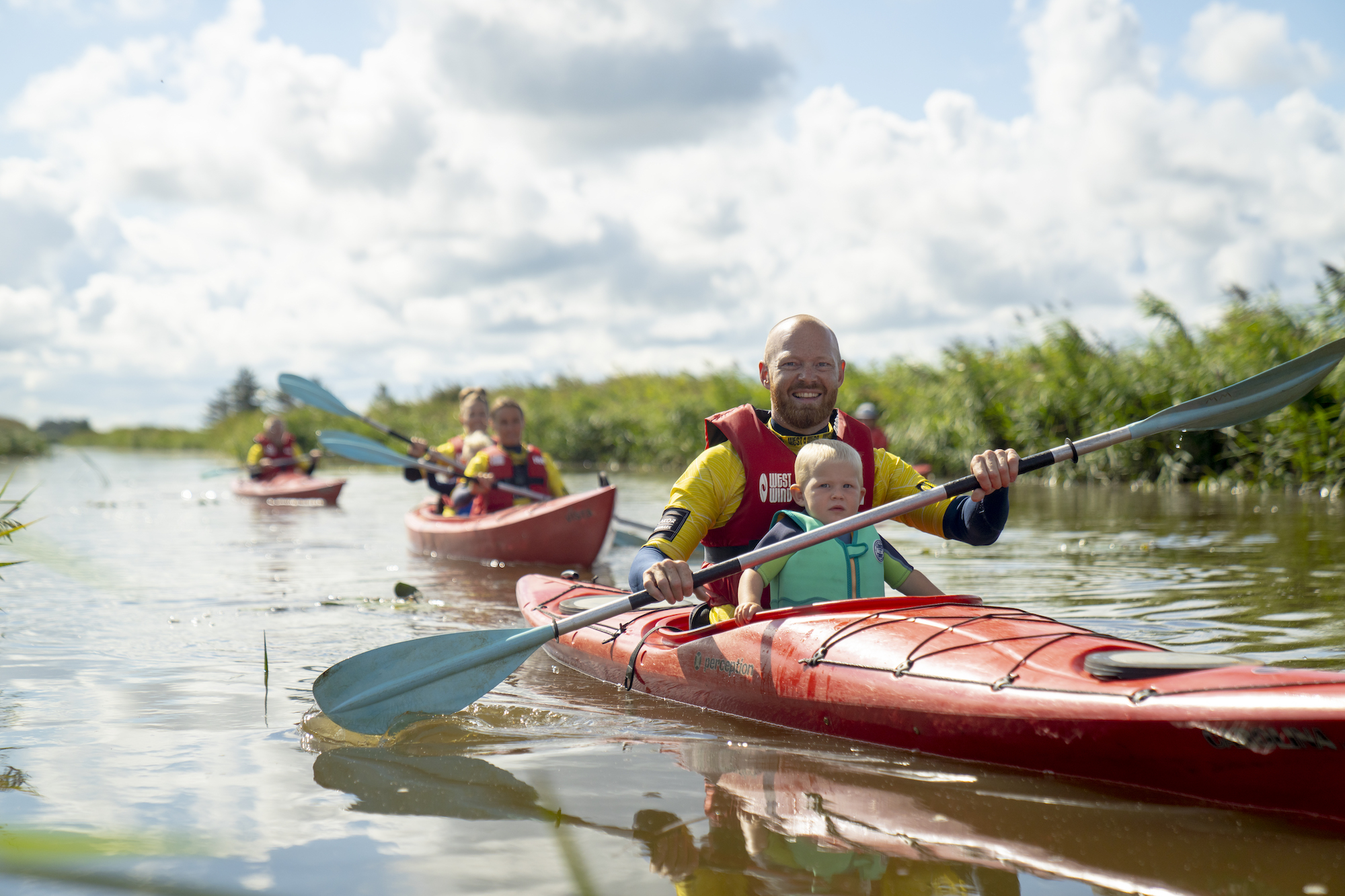 Far og søn sejler i kajak i å