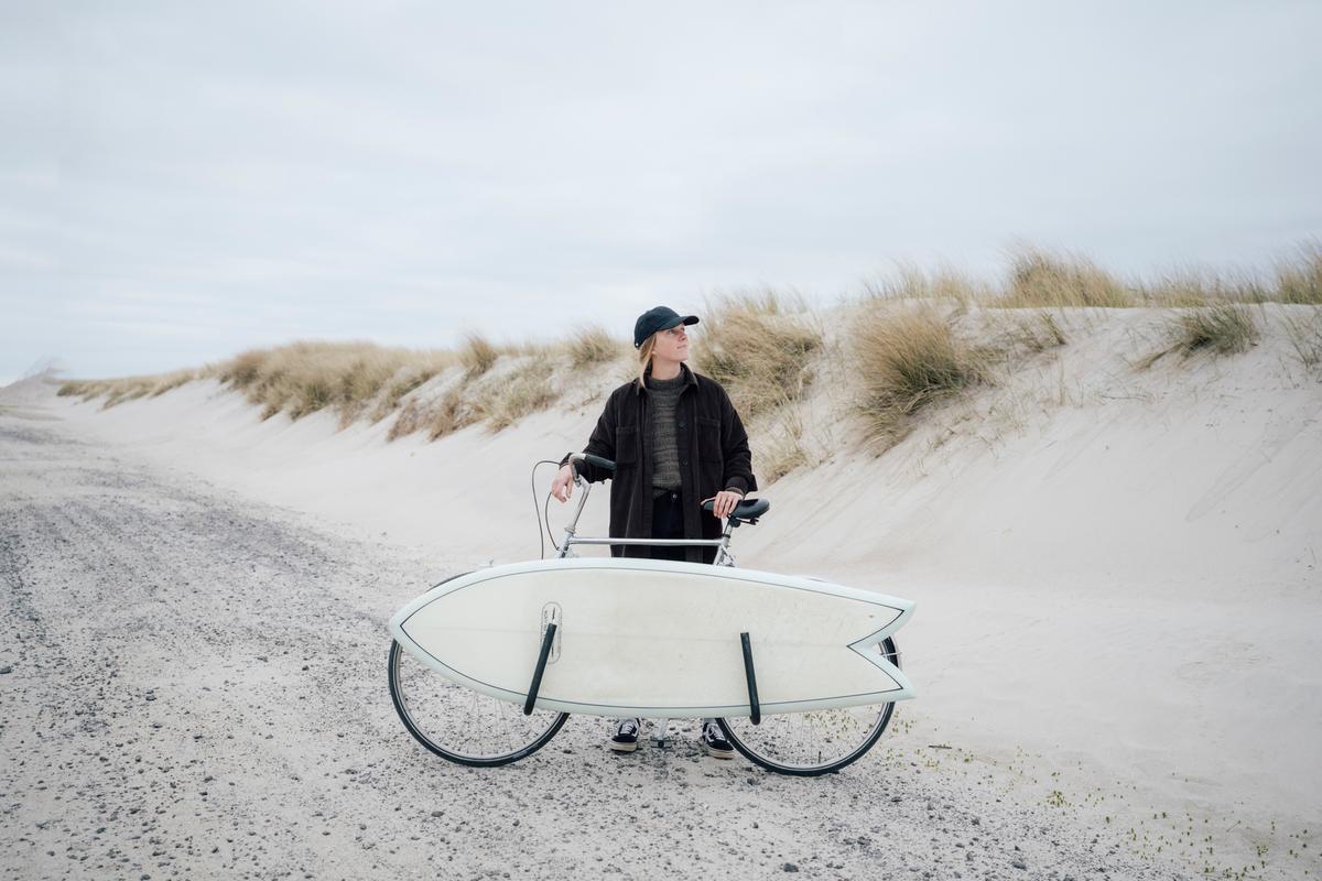En surfer med cykel ved vestkysten