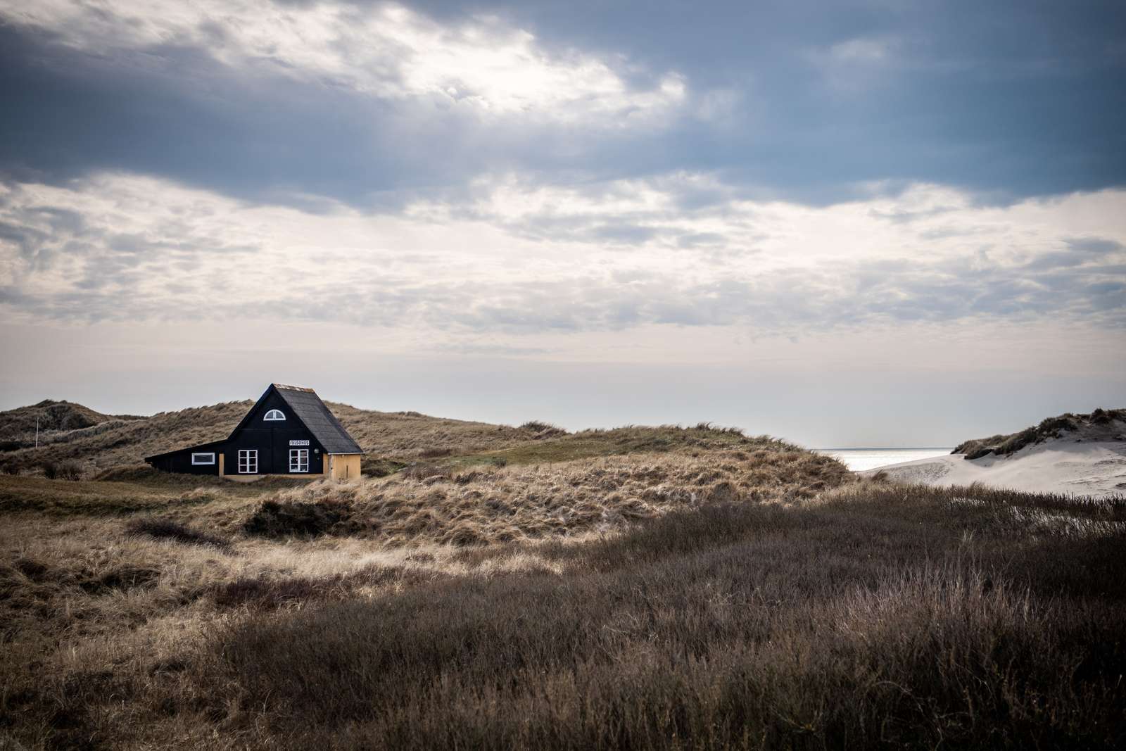 Udsigt til et gult feriehus og Henne Strand