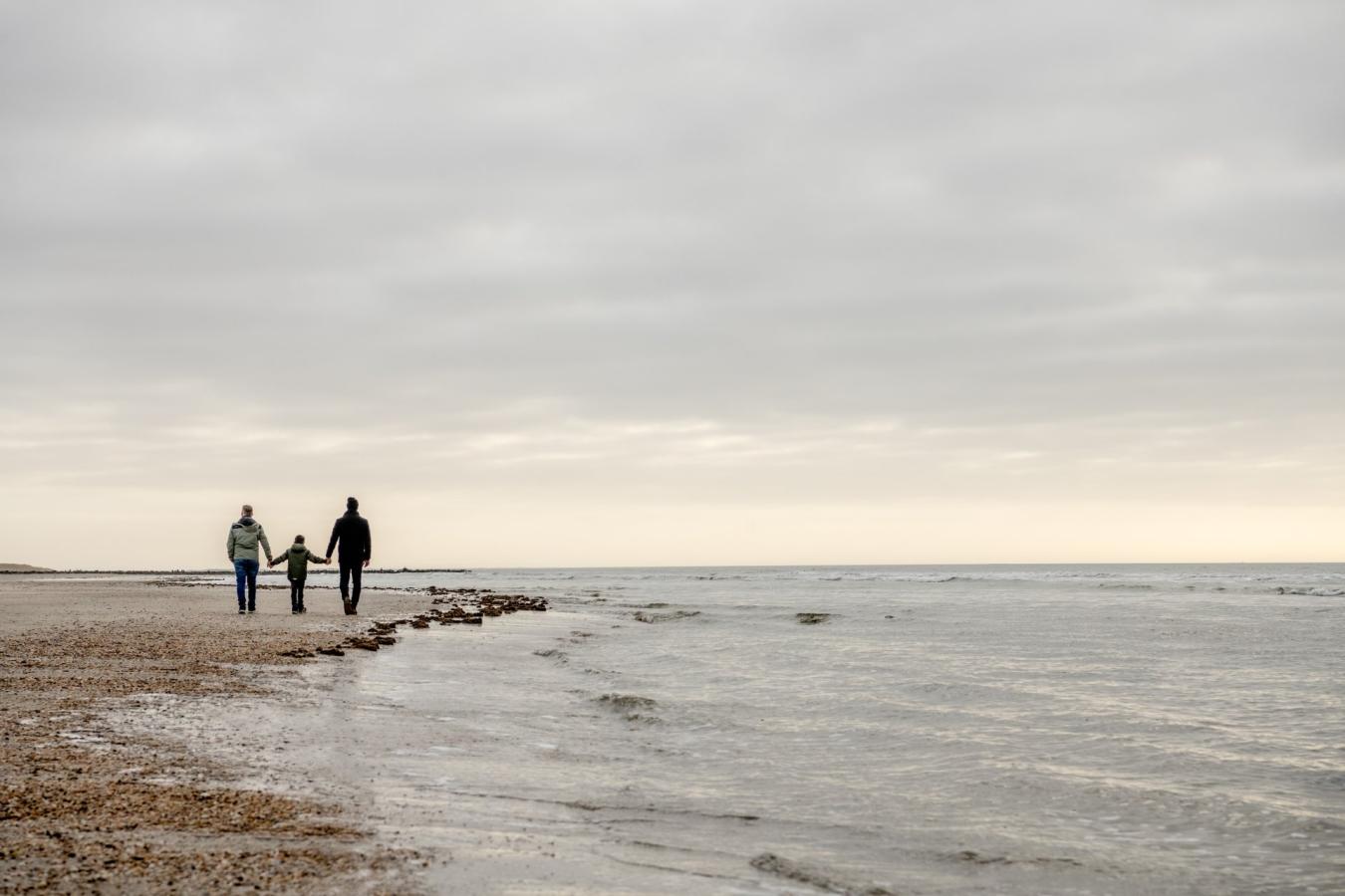 Familie på gåtur på strande i Blåvand