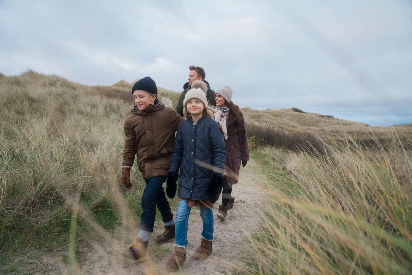 Børnefamilie ved vesterhavet går en tur i klitter